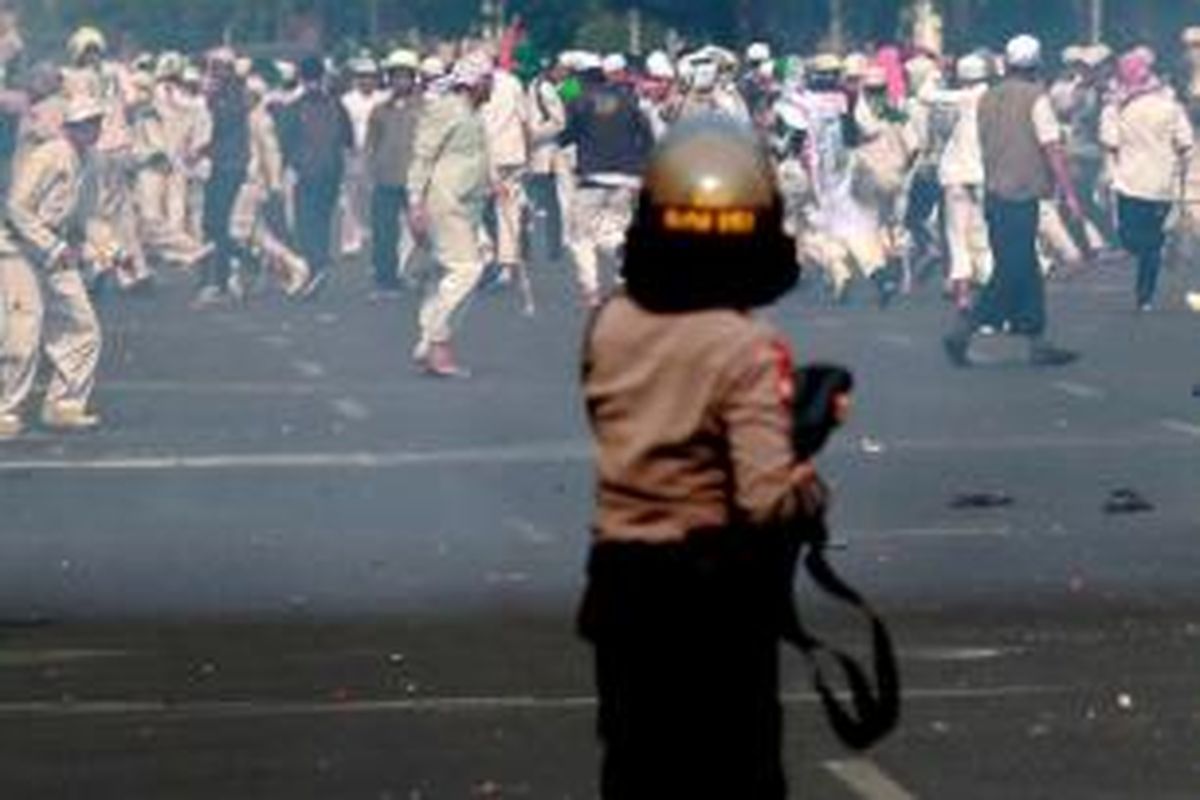 Polisi menghadapi massa Front Pembela Islam (FPI) yang melemparkan batu ke arah Gedung DPRD DKI Jakarta saat terjadi kerusuhan menyusul aksi unjuk rasa FPI, Jumat (3/10/2014). Massa FPI berdemo menolak Ahok diangkat menjadi Gubernur DKI Jakarta.