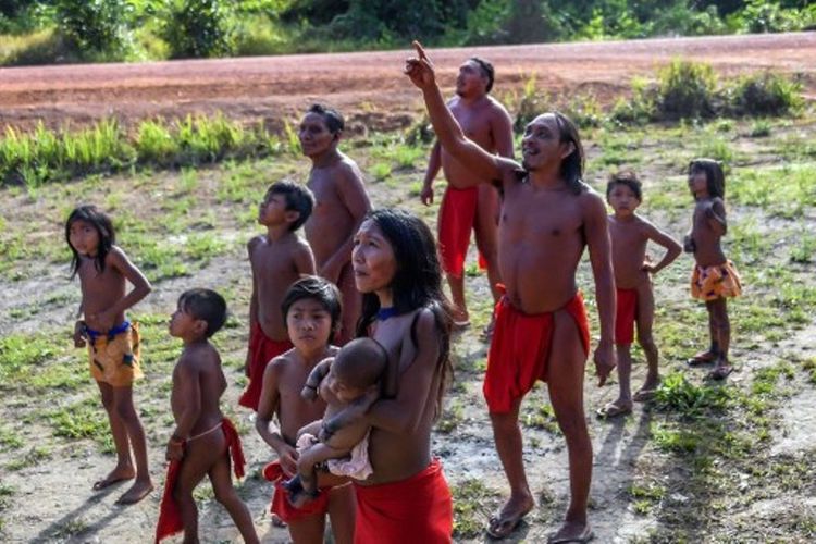 Penduduk Waiapi melihat sebuah pesawat terbang di langit di Amapa, Brasil pada 15 Oktober 2017. (AFP/Apu Gomes)