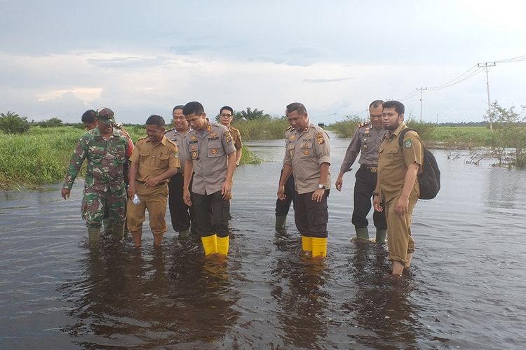 Kapolres Rohul AKBP Dasmin Ginting berserta sejumlah pejabat, TNI dan Pemerintah Kecamatan Bonai Darussalam meninjau banjir di ruas jalan lintas Riau-Sumut di Desa Sontang, Kecamatan Bonai Darussalam, Kabupaten Rohul, Riau, Senin (2/12/2019).