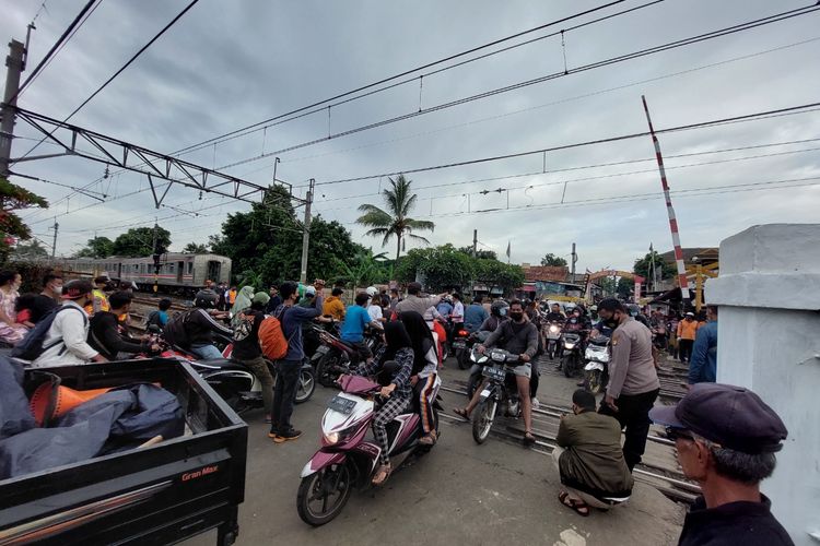Pengendara kendaraan yang dapat melewati pelintasan sebidang di Jombang, Ciputat, Kota Tangerang Selatan, Minggu (5/12/2021), setelah KRL yang anjlok digeser.