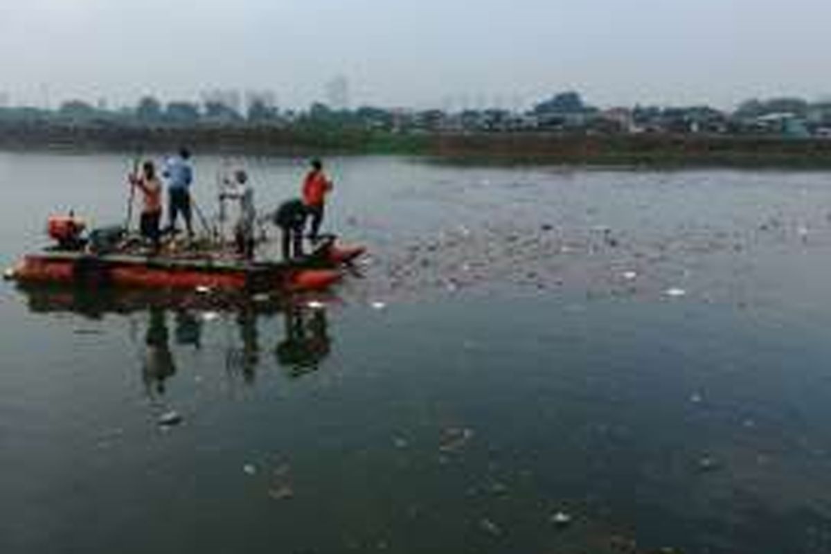 Para pekerja dari Unit Pengelola Kebersihan (UPK) Badan Air Dinas Kebersihan DKI di Waduk Ria Rio, Pulogadung, Jakarta Timur turun dengan perahu untuk membersihkan sampah yang mengotori waduk setelah hujan. Senin (19/9/2016).