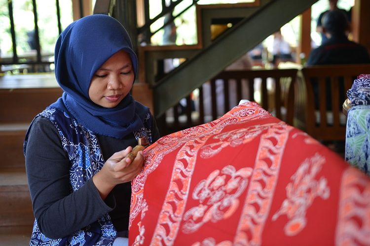 Seorang pembatik sedang mengerjakan salah satu motif batik Betawi.