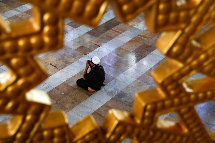 Pria muslim memakai masker saat beribadah di masjid di hari pertama bulan suci Ramadhan, di tengah mewabahnya virus corona (Covid-19), di Bangkok, Thailand, Jumat (24/4/2020). Di tengah pandemi Covid-19, Ramadhan tahun ini berlangsung dengan suasana sepi, berbeda dengan tahun-tahun sebelumnya.