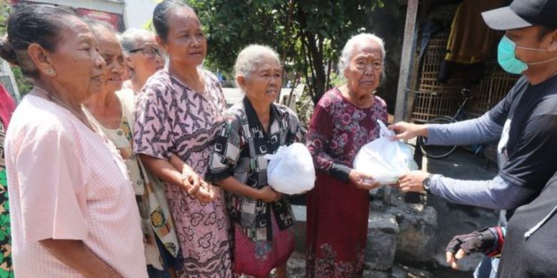 Warga antre untuk mendapatkan bantuan sembako di Kelurahan Pojok, Kota Kediri, Jawa Timur, Selasa (07/04). 