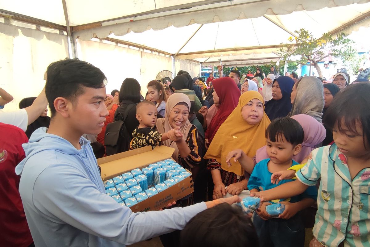 Calon wakil presiden nomor urut 2, Gibran Rakabuming, membagi-bagikan susu kepada masyarakat kampung nelayan Mangara Bombang, Makassar, Sulawesi Selatan, Sabtu (25/11/2023).