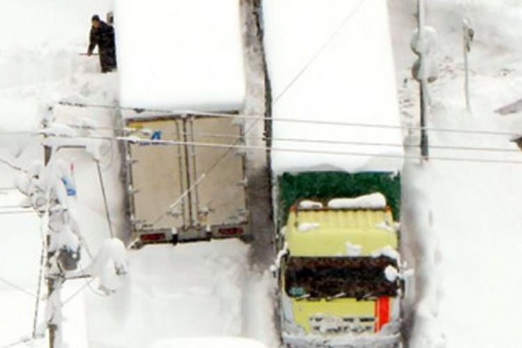 Sejumlah truk terperangkap dalam badai salju di Chizu, Prefektur Tottori, Jepang, Selasa (24/1/2017).  