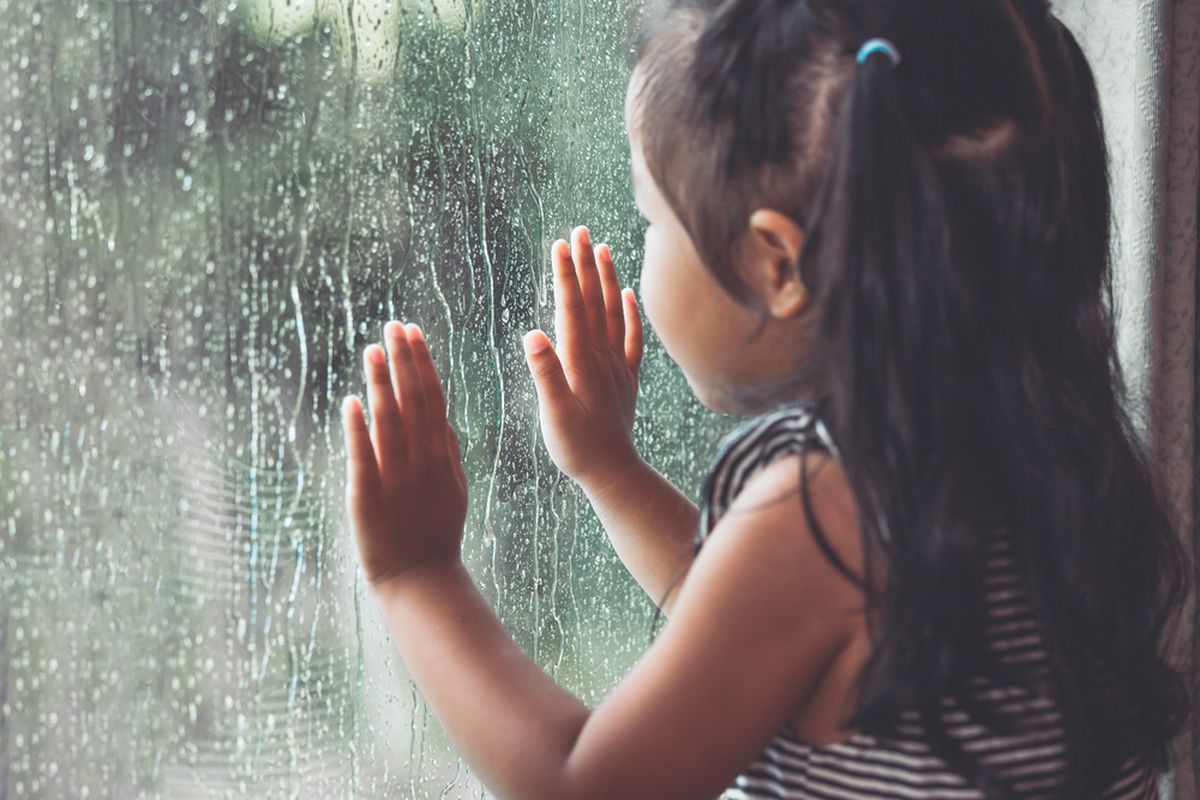 Ilustrasi anak melihat hujan. Penting untuk memerhatikan kesehatan anak selama musim hujan agar tak mudah terjangkit penyakit.