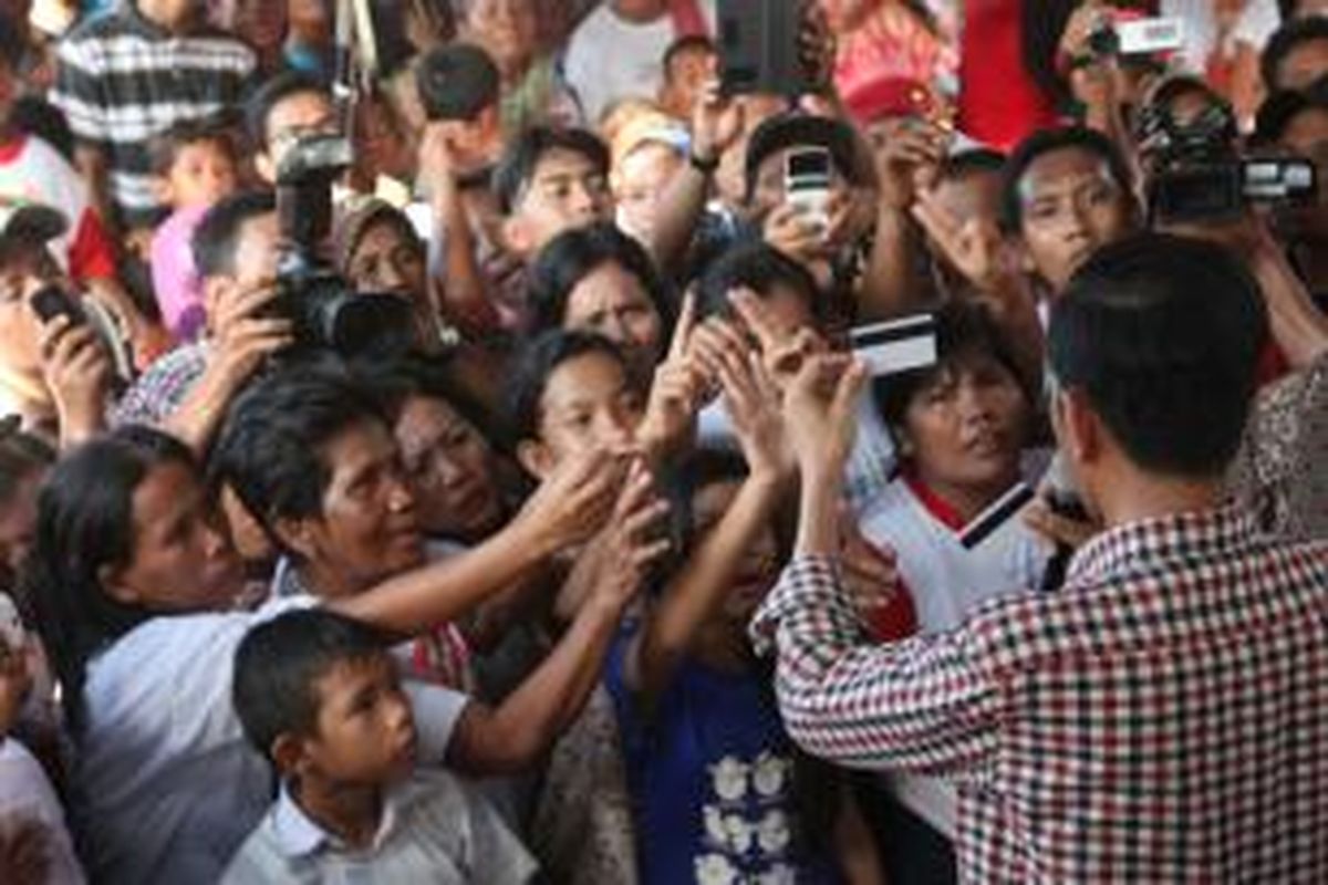 Capres, Joko Widodo menunjukkan Kartu Indonesia Pintar disela-sela dialognya dengan  nelayan di Kampung Nelayan Indah, Belawan, Sumatera Utara, Selasa (10/6/2014). Ia berjanji mencarikan solusi atas keluh kesah nelayan yang disampaikan kepadanya.