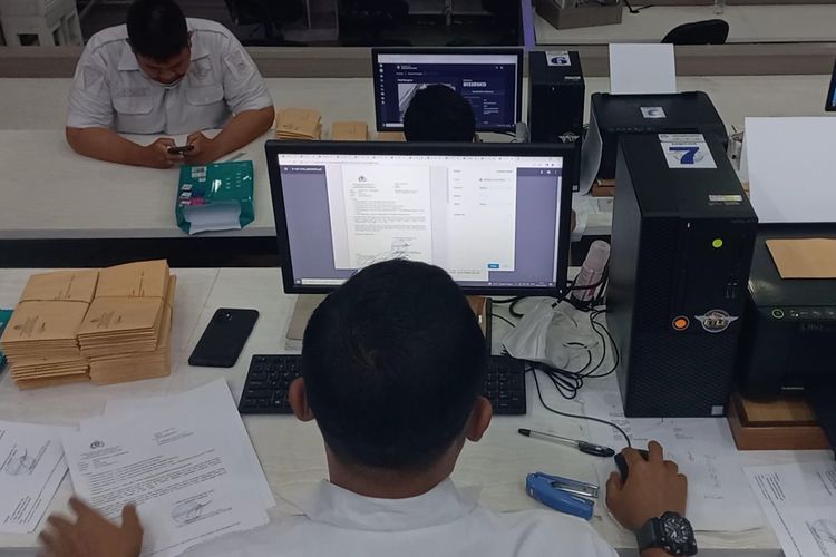 Petugas kepolisian hendak mencetak surat konfirmasi tilang usai memverifikasi gambar hasil tangkapan kamera tilang elektronik atau ETLE, Selasa (5/4/2022) di gedung Traffic Management Center (TMC) Polda Metro Jaya.