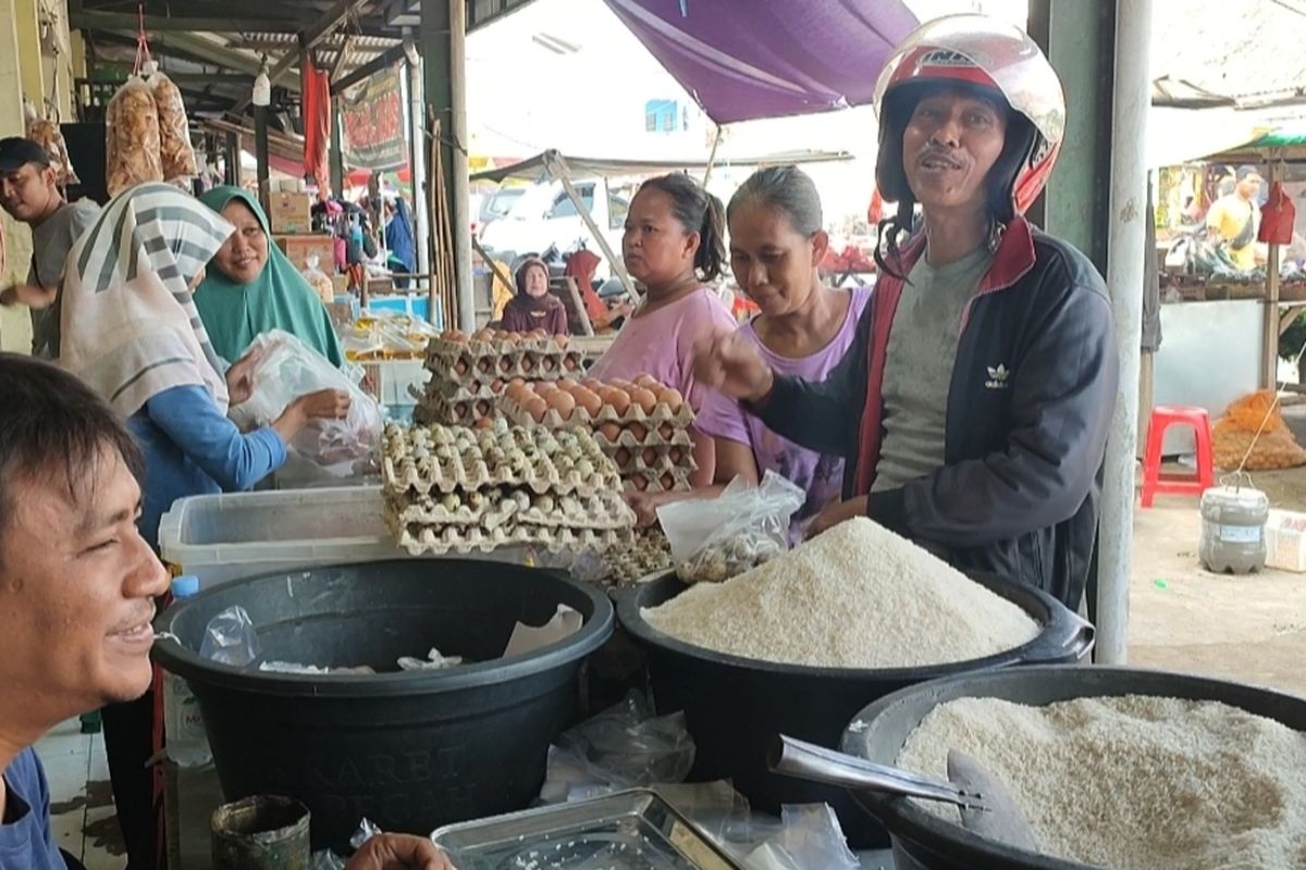 Kusnan (pembeli berhelm) meminta pemerintah dan pedagang menurunkan harga beras yang sudah sangat tinggi. Keluhan ini disampaikan nya saat belanja beras di Pasar Jamblang Selasa (20/2/2024) pagi.