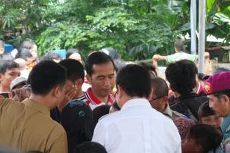 Gubernur DKI Jakarta Joko Widodo dikerumuni warga saat menghadiri deklarasi Jakarta sebagai kota layak anak. Acara itu digelar di kolong tol Plumpang, Jakarta Utara.