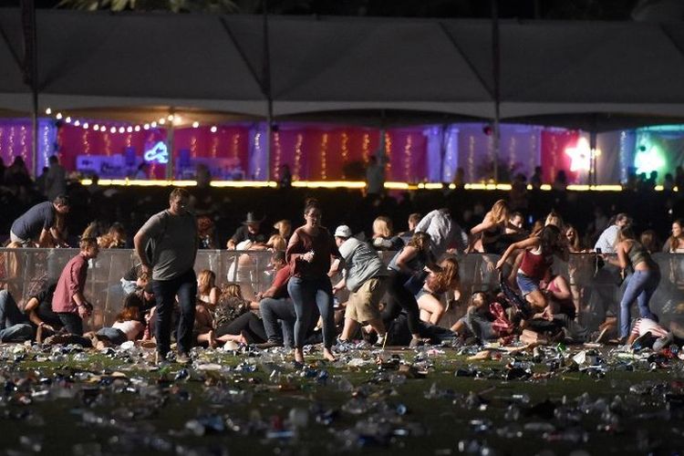Orang-orang berlarian meninggalkan lokasi festival musik country Route 91 Harvest setelah mendengar suara tembakan senjata di Las Vegas, Nevada, Amerika Serikat, Minggu (1/10/2017). Pelaku penembakan diperkirakan berada di sekitar Mandalay Bay Resort and Casino.