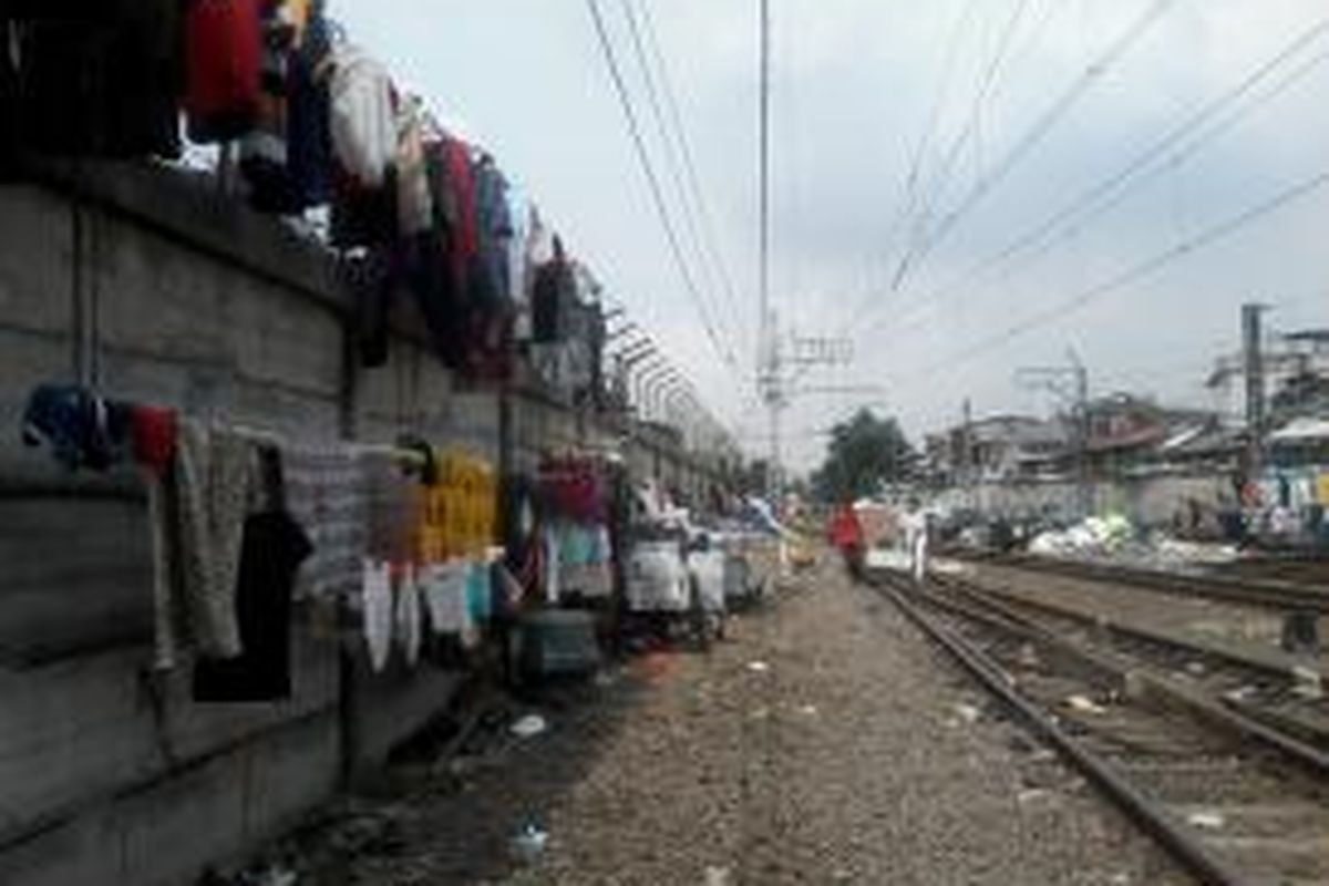 Warga Kampung Deret Tanah Tinggi menjemur pakaian di sekitar rel kereta api dekat Stasiun Pasar Senen, Jakarta Pusat, Senin (15/7/2013). Mereka terpaksa menjemur pakaian di tempat tersebut karena rumah yang mereka tinggali tengah direnovasi menjadi kampung deret.