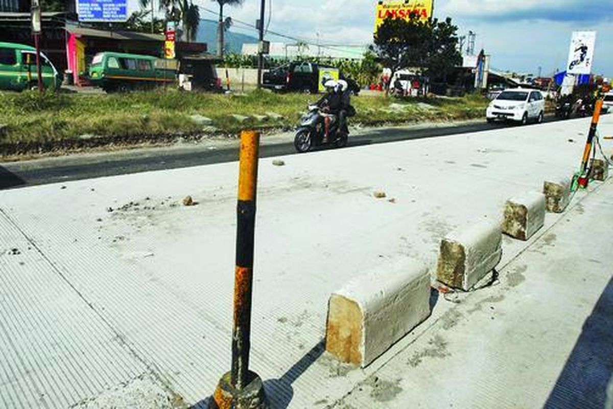  Sejumlah kendaraan melintasi proyek pengerjaan penebalan ruas jalan di Cileunyi, Kabupaten Bandung, Jawa Barat, Kamis (19/7). Ruas jalan yang akan dilalui warga sebagai jalur mudik Lebaran di Jabar saat ini terus dibenahi. 