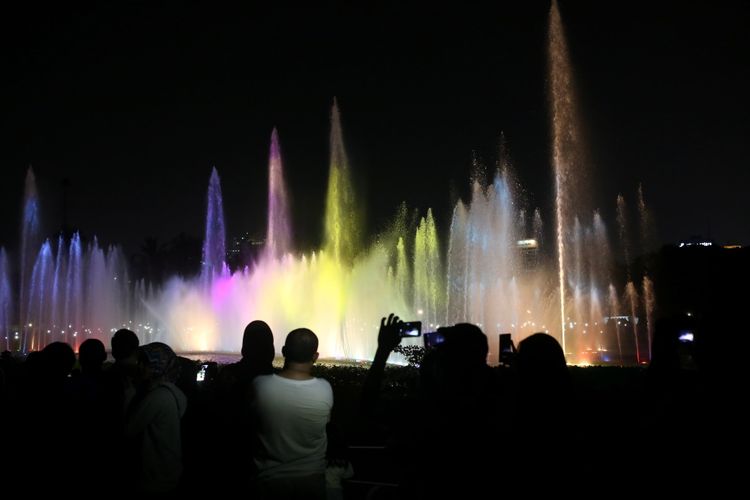 Warga menonton air mancur menari atau Jakarta Monas Fountain di Monas, Jakarta Pusat, Minggu (13/8/2017). Air mancur menari kembali diresmikan oleh Gubernur DKI Jakarta Djarot Saiful Hidayat setelah rampung diperbaiki sejak rusak pada 2009 lalu dan air mancur menari Monas akan beraksi dua kali setiap Sabtu dan Minggu malam yakni pukul 19.30 dan 20.30 WIB.