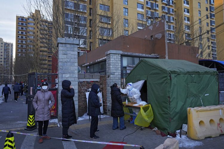 Warga mengantre untuk mengambil sampel usap tenggorokan di lokasi tes virus corona di luar blok perumahan di Distrik Fengtai, Beijing, Rabu, 26 Januari 2022. 