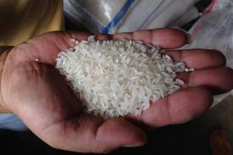 Pedagang beras di Pasar Induk Tanah Tinggi, Tangerang, menunjukkan contoh beras yang sebenarnya, Kamis (21/5/2015) pagi. Pedagang beras harus menghadapi berbagai pertanyaan dari pembeli sejak ditemukannya beras plastik yang meresahkan masyarakat.