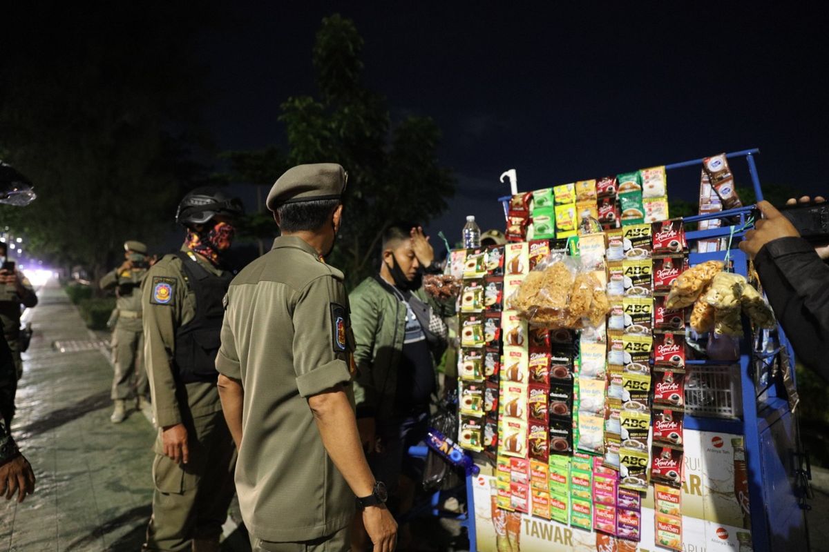 Petugas gabungan melakukan penertiban kepada pedagang kaki lima (PKL) di sepanjang Jalan Danau Sunter Selatan, Tanjung Priok, Jakarta Utara, Kamis (11/2/2021) malam.