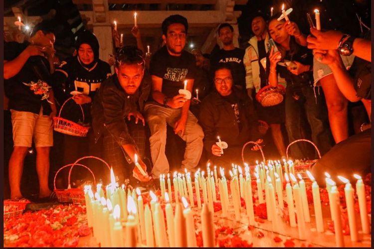 Kapten Persebaya, Alwi Slamat, menyalakan lilin dalam acara solidaritas dan doa bersama untuk kobran tragedi Kanjuruhan yang dilaksanakan di kawasan Tugu Pahlawan, Surabaya, pada Senin (3/10/2022) malam WIB. (Sumber foto: Tangkapan layar Twitter Persebaya/@persebayaupdate)