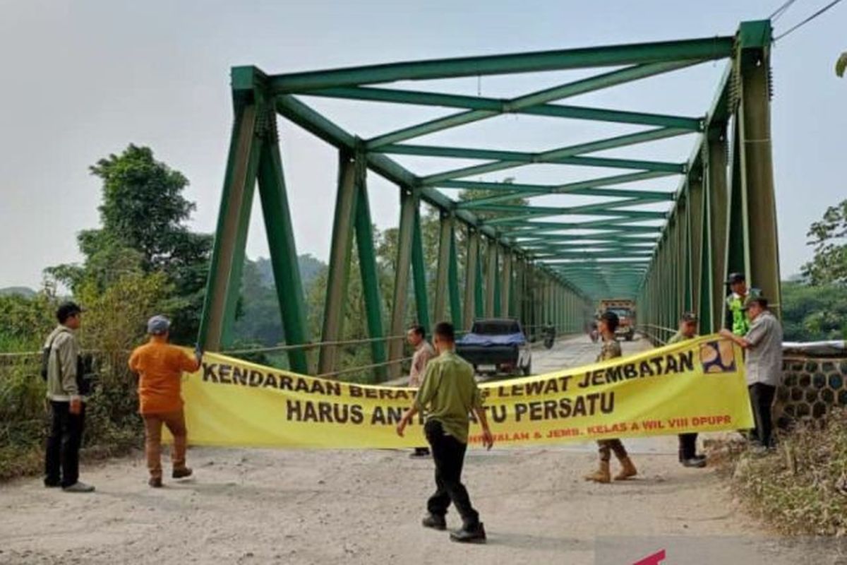 Pemasangan spanduk peringatan di Jembatan Leuwiranji, Kabupaten Bogor, Jawa Barat, Selasa (25/7/2023).