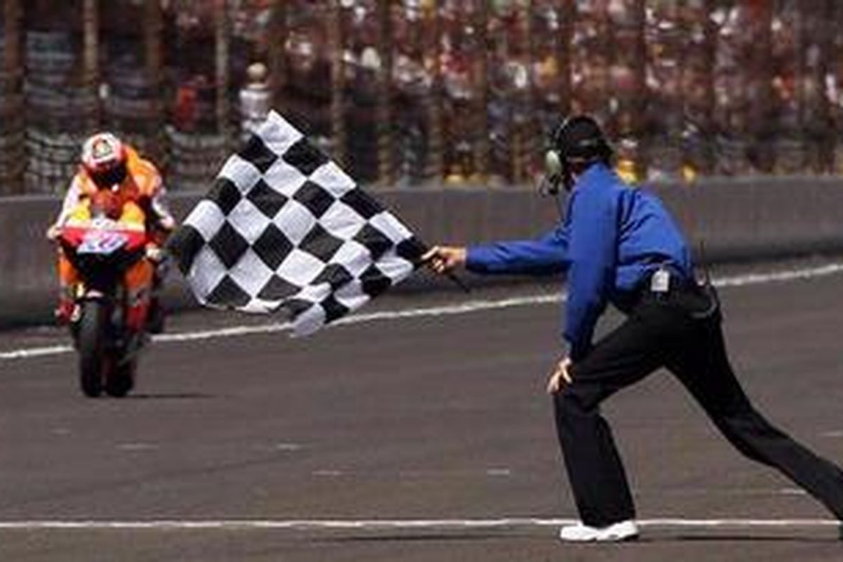 Pebalap Repsol Honda, Casey Stoner, ketika memasuki garis finis GP Indianapolis, Minggu (28/8/11).