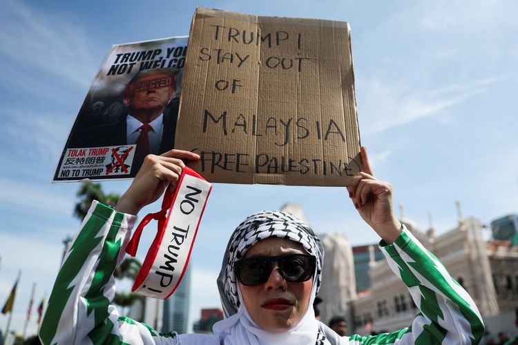 Seorang demonstran pro-Palestina mengangkat plakat selama protes terhadap kehadiran Presiden AS Donald Trump di KTT ASEAN ke-47, di Kuala Lumpur, Malaysia, 26 Oktober 2025. 