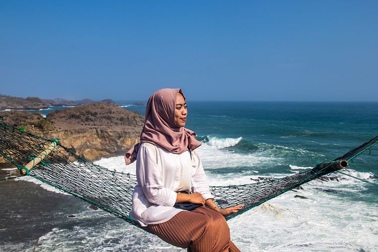 Pengunjung Pantai Kasap Pacitan Berfoto di Atas Hammock.