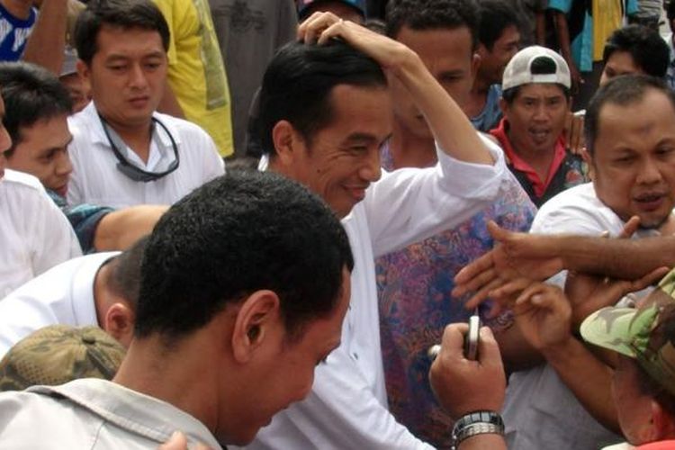 Bakal calon presiden yang diusung Partai Demokrasi Indonesia Perjuangan (PDIP) dan sejumlah partai pendukung, Joko Widodo (Jokowi) dikerubuti warga dan pedagang setibanya di Pasar Segiri, Jalan Pahlawan, Samarinda, Sabtu (24/5/2014). Pada akhir pekan ini, Jokowi melanjutkan safari politiknya dengan mengunjungi beberapa kota di Kalimantan Timur, di antaranya Balikpapan, Samarinda, dan Tenggarong.