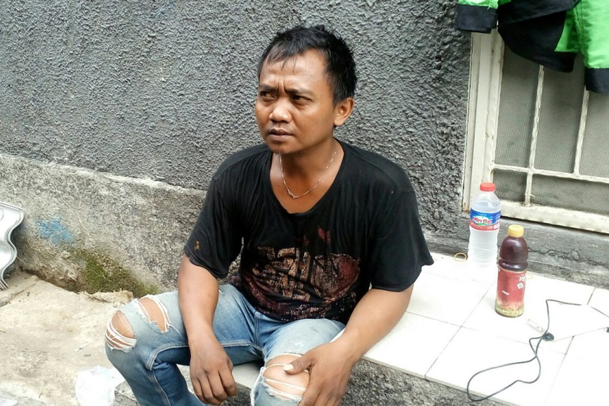 Muhamad Tajudin (31), driver ojek online yang membawa kedua anaknya saat bekerja. Foto diambil pada Selasa (26/9/2017).