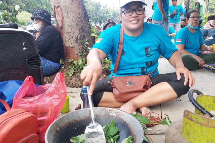 Warga Kampung Susun Bayam sedang memasak sayur bayam ketika menggelar unjuk rasa di Balai Kota DKI Jakarta, Jakarta Pusat, Kamis (1/12/2022).