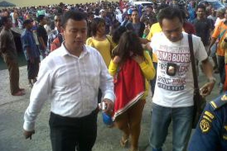 Dua anggota kepolisian membawa turun para korban perdagangan manusia dari Kapal Ngapulu di Pelabuhan Yos Sudarso, Ambon, Senin (2/9/2013).