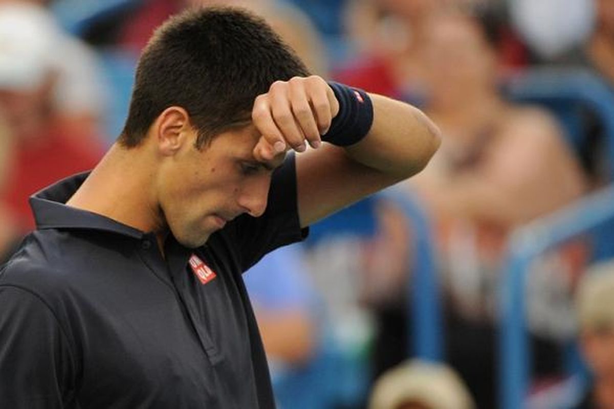 Petenis Serbia, Novak Djokovic mengelap keringat ketika menjalani laga babak kedua Western & Southern Open melawan petenis Perancis, Gilles Simon, di Cincinnati, Selasa (12/8/2014). Djokovic menang 6-3, 4-6, 6-4.