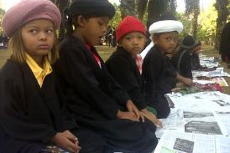 Sejumlah bocah di pesisir danau Mawang, Kabupaten Gowa, Sulawesi Selatan mengikuti ibadah sholat Idul Fitri yang digelar oleh Jemaah An Nazir. Kamis, (16/07/2015).