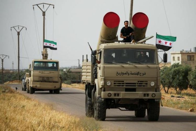 Pasukan pemberontak Suriah mengangkut misil menggunakan truk saat parade militer di dekat Daraa.