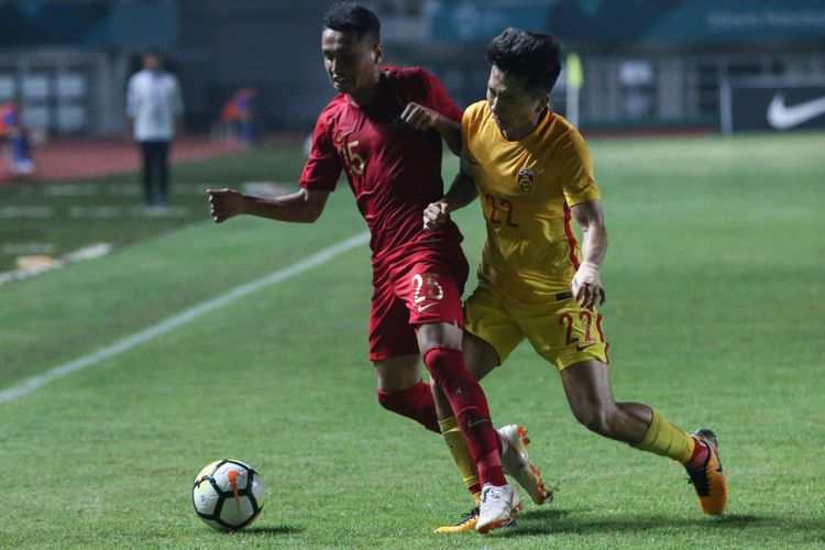 Pemain Tinas U-19 Indonesia, Aulia Hidayat (kiri) berebut bola dengan pemain Timnas China, Jiabao Wen saat laga PSSI 88 th U-19 International Tournament di Stadion Pakansari, Cibinong, Bogor, Selasa (25/9/2018). China kalahkan Indonesia denken skor 3-0.