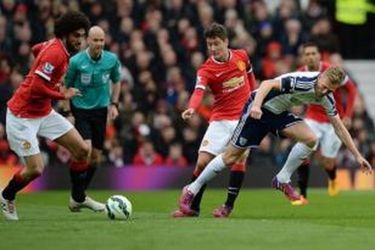 Dua gelandang Manchester United, Marouane Fellaini (kiri) dan Ander Herrera bertarung dengan penggawa West Bromwich Albion, Darren Fletcher, Sabtu (2/5/2015).