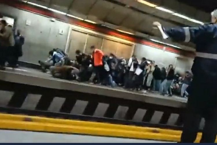 Tangkap layar rekaman video menunjukkan orang-orang berlarian keluar dan polisi dengan pentungan memukuli wanita di gerbong metro pada Selasa (15/11/2022).