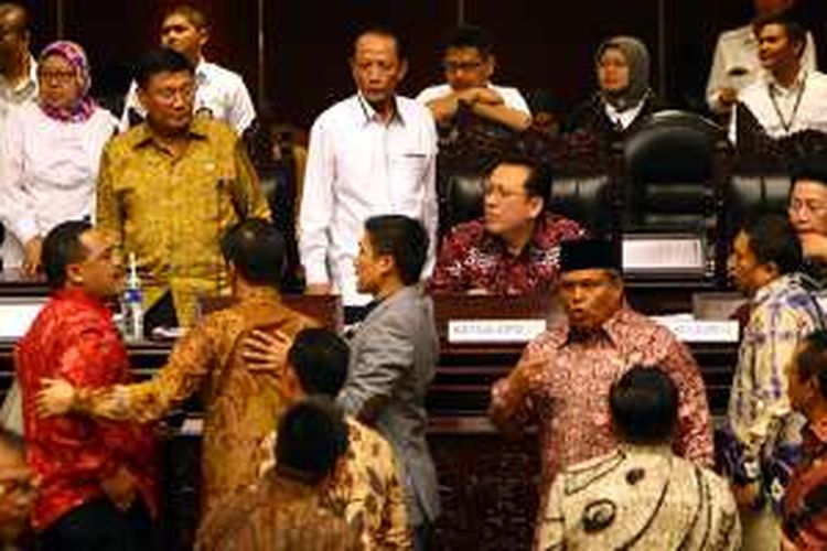 Anggota DPD ditenangkan oleh sesama anggota lainnya saat melakukan interupsi pada sidang paripurna di Gedung Parlemen Senayan, Jakarta, Senin (11/4/2016).