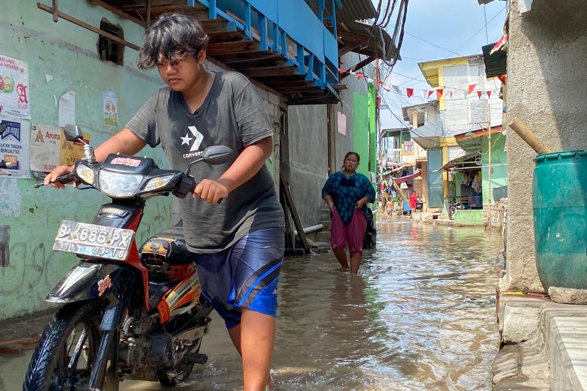 Banjir rob merendam ruas jalan di Muara Angke, Penjaringan, Jakarta Utara pada Rabu (21/12/2022). Banjir setinggi 20-30 sentimeter itu melanda sejumlah titik ruas jalan di Muara Angke hingga membuat pejalan kaki dan oengendara sepeda motor harus melintas dengan hati-hati.