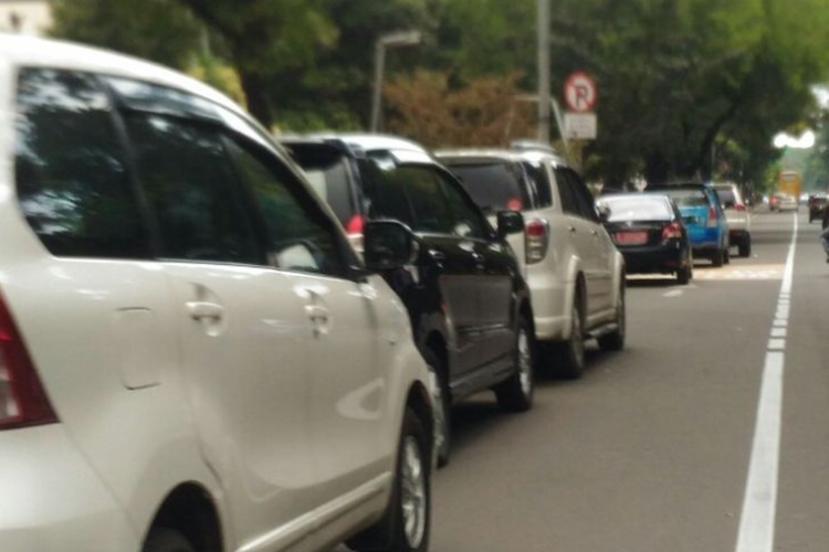 Lajur paling kiri yang diperuntukkan bagi pengendara sepeda motor dijadikan tempat parkir mobil di Jalan Medan Merdeka Barat, Rabu (24/1/2018).