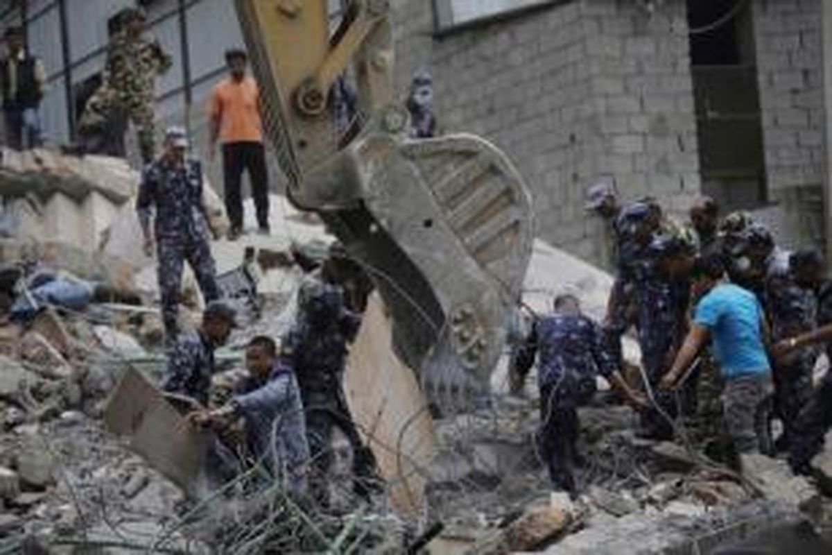 Petugas membersihkan puing reruntuhan hotel setelah diguncang gempa berkekuatan 7.9 SR di Kalanki, Kathmandu, Nepal, 16 April 2015.