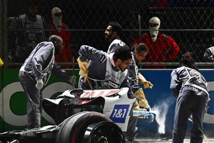Para marshal tengah membersihkan titik kecelakaan pebalap Haas Mick Schumacher dalam sesi kualifikasi F1 GP Qatar di Sirkuit Jeddah Corniche pada Minggu (27/3/2022) dini hari WIB.