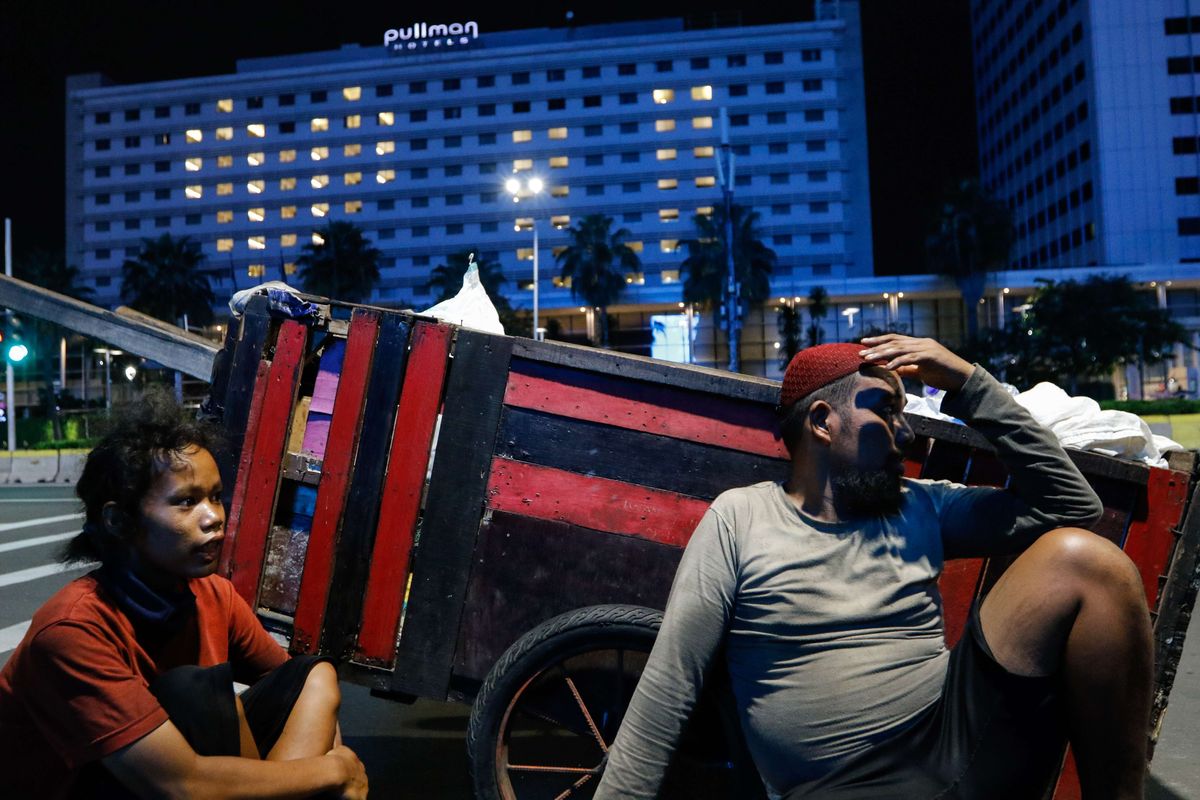 Two junk collectors, Yunita (left) and Ilham Saputra, rest in the middle of their work at the MH Thamrin throroughfare on Monday, (22/4/2020). Statistics Indonesia or the BPS announced that more than 4 million Indonesians are unemployed or underemployed due to the fallout from Covid-19