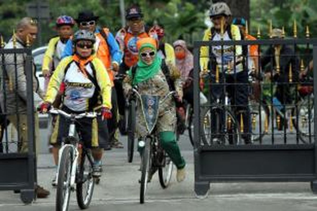 Pegawai negeri sipil (PNS) Pemprov DKI Jakarta menggunakan sepeda memasuki Balaikota, Jumat (3/1/2014). Pemprov DKI Jakarta melalui instruksi gubernur (Ingub) melarang PNS menggunakan kendaraan pribadi pada hari Jumat di pekan pertama setiap bulan, hanya kendaraan operasional milik Pemprov DKI yang boleh berlalu lalang di jalanan Ibu Kota. 