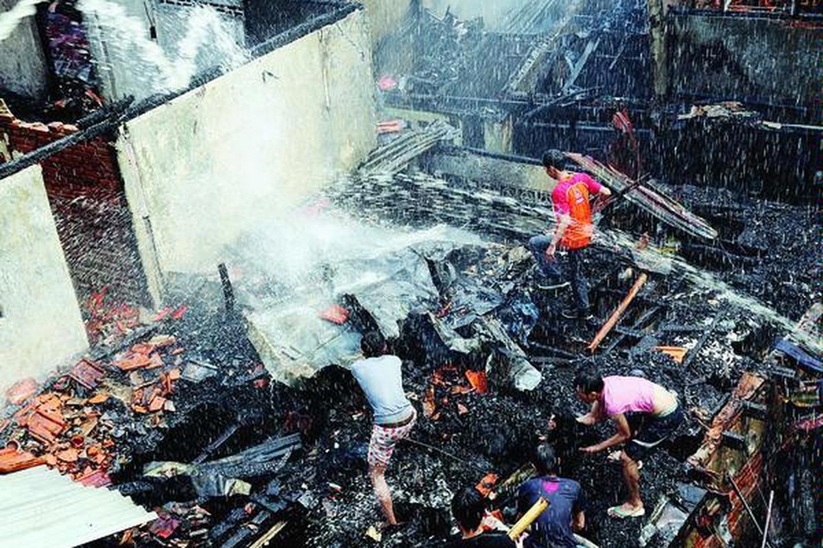 Warga ikut turun ke lokasi kebakaran saat dilakukan pendinginan di lokasi kebakaran di permukiman padat penduduk yang meluluhlantakkan sekitar 30 rumah petak,  di Kramat Pulo di samping Pasar Gaplok, Senen, Jakarta, Jumat (24/8).