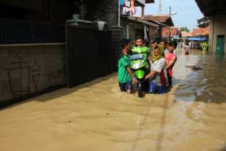 Sejumlah warga di Desa Gebang Udik, Kecamatan Gebang, Kabupaten Cirebon, Jawa Barat, berusaha memindah barang-barang ke tempat aman, Senin (2/1/17). Lebih dari dua ratus rumah warga terendam banjir sejak Minggu malam, karena Sungai Ciberes meluap. 