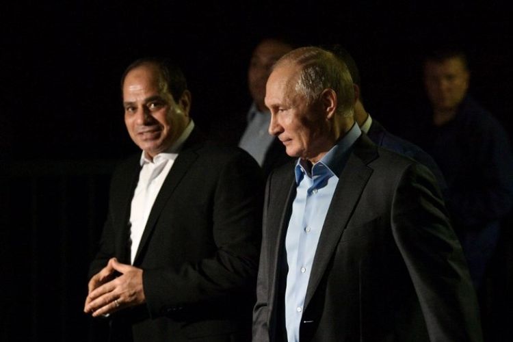 Presiden Rusia Vladimir Putin (kanan) dan Presiden Mesir Abdel Fattah Al-Sisi (kiri) berjalan di sepanjang tepi laut Olympic Park, di Sochi, Rusia pada Selasa (16/10/2018). (AFP/Sputnik/Alexei Druzhinin)