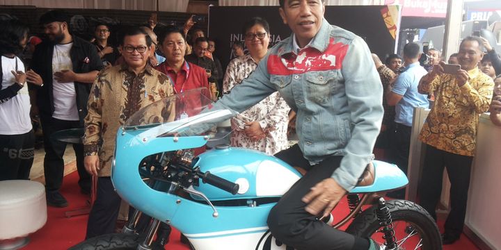 Presiden Joko Widodo menaiki salah satu sepeda motor Honda CB 125 lawas yang dipamerkan di stan Increase saat berlangsungnya hari pertama pameran Indonesia International Motor Show (IIMS) 2018, di JIExpo Kemayoran, Jakarta, Kamis (19/4/2018). Motor yang dimodifikasi bergaya caferacer merupakan milik putra sulung Jokowi, Gibran Rakabuming.