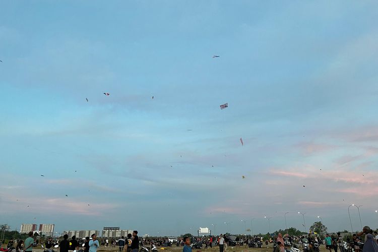 Suasana masyarakat mulai dari anak-anak, remaja, hingga orang tua yang bermain layangan di tanah lapang area sekitar Pondok Candra, Kecamatan Waru, Sidoarjo pada Kamis (17/7/2025).