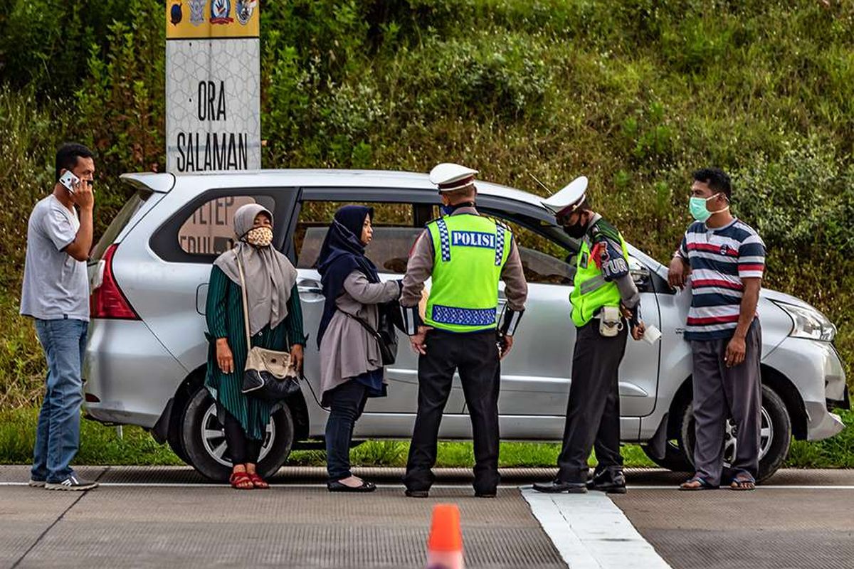 Polisi menginterogasi sejumlah penumpang yang diduga menumpang mobil bernomor polisi palsu saat penyekatan pemudik di Gerbang Tol Kalikangkung, Semarang, Jawa Tengah, Selasa (26/5/2020). Satlantas Polrestabes Semarang mencatat sejak pukul 07.00-17.00 WIB sebanyak 276 kendaraan roda empat maupun bus yang mengangkut pemudik menuju Jakarta melalui gerbang tol tersebut diperintahkan untuk berputar balik karena tidak dilengkapi surat izin keluar-masuk (SIKM).